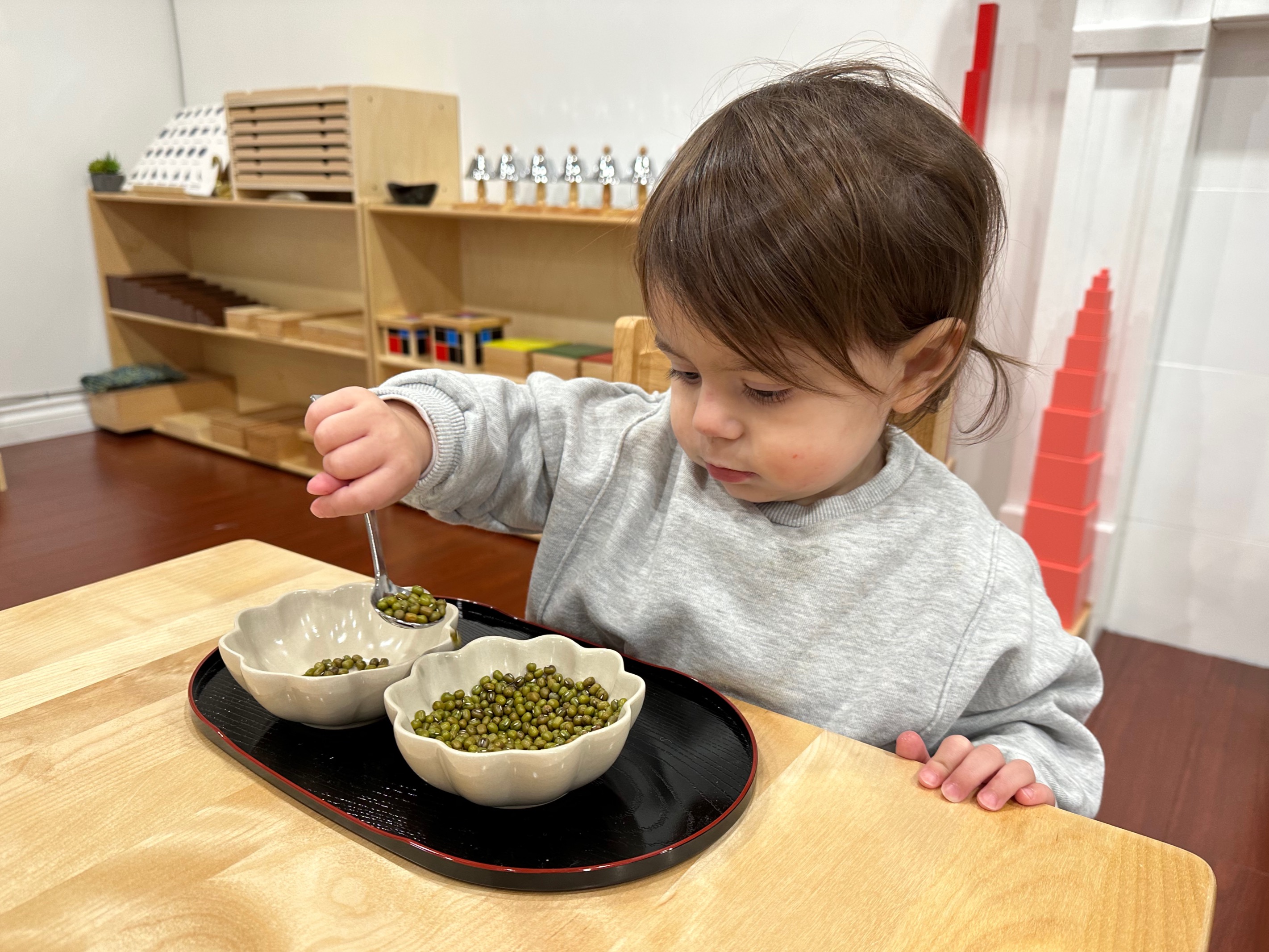 A child concentrating on Montessori material work